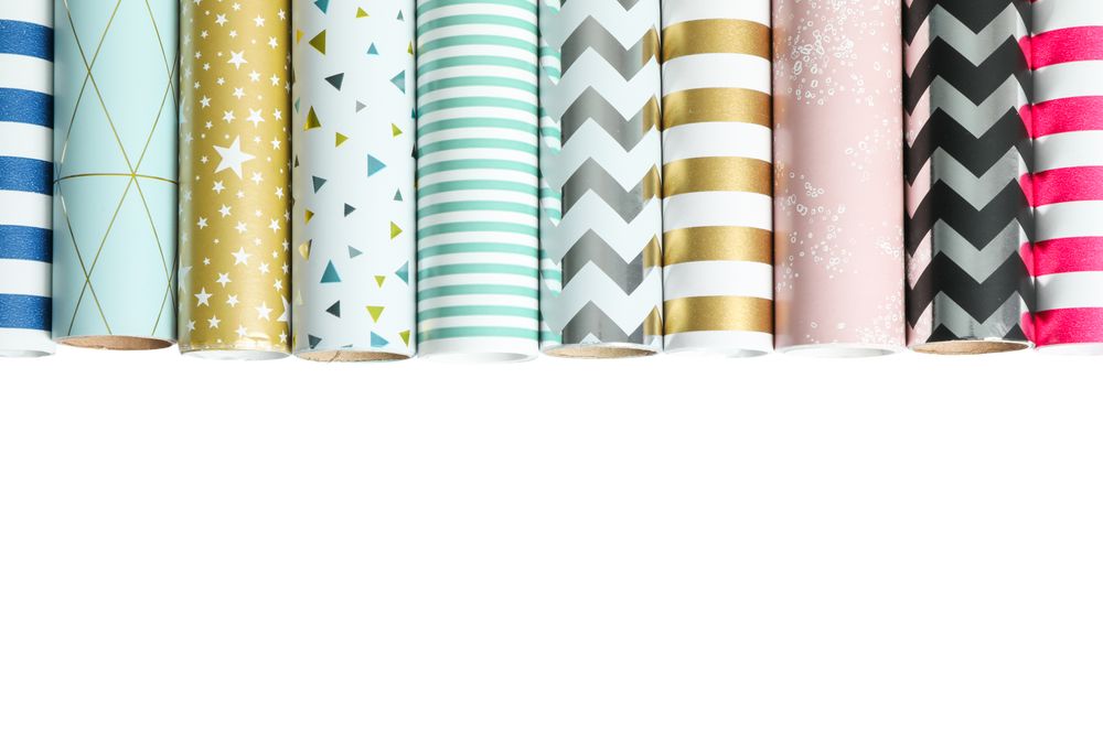 Rolls of festive wrapping paper on blank background. Space for text