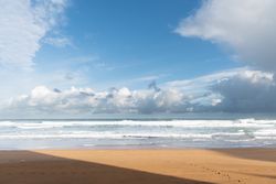 Landscape of lonely sandy seashore with blue sky
