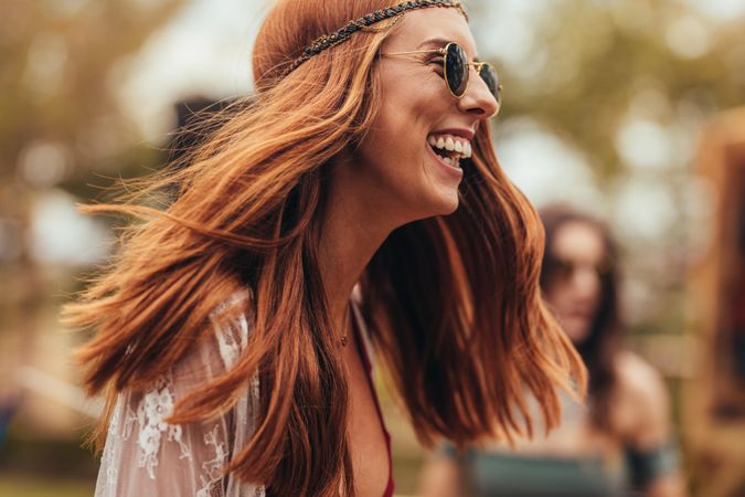 Laughing young woman in retro look at music festival