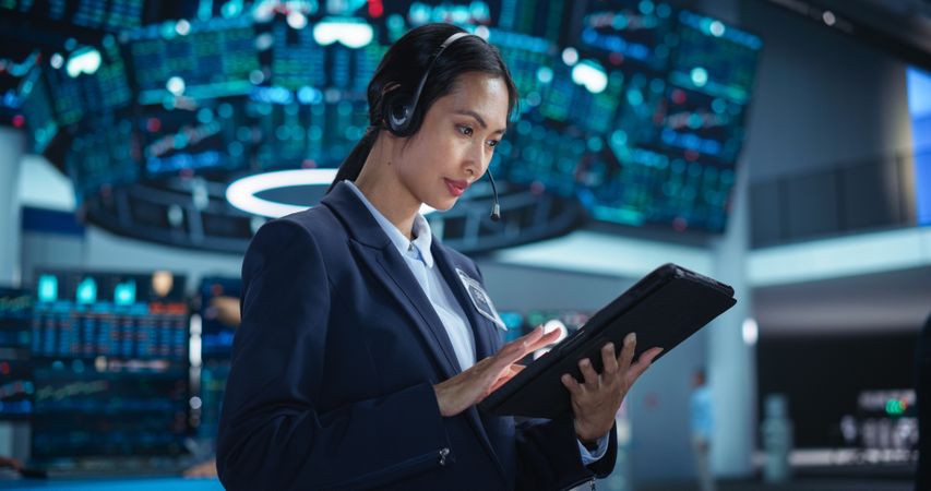 Portrait of a Young Stock Exchange Broker Using Tablet Computer, Researching Real-Time Stocks Data, Analyzing Commodities and Exchange Market Charts.