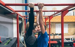 Athletes kissing exercising on monkey bars