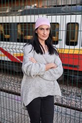woman standing on railway station with folded arms and