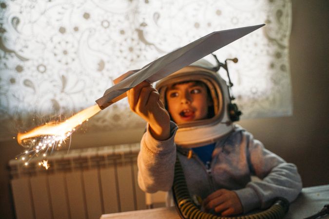 Dreamy kid having fun with toy airplane