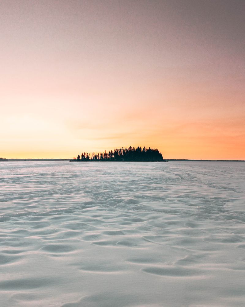 Small island from afar in the middle of the sea during sunset