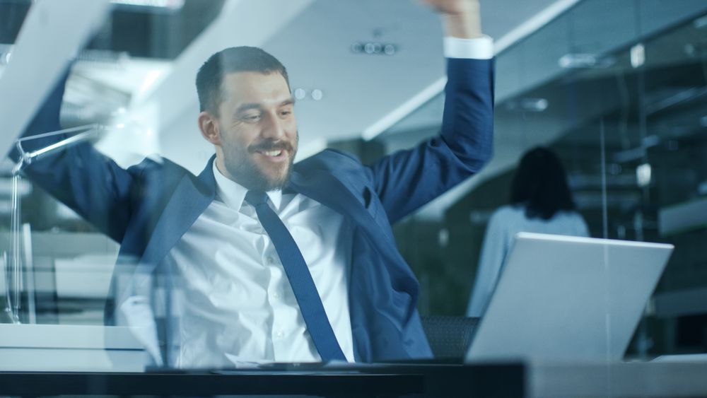 Businessman Works on a Laptop at His Desk, He Finished Job, Broke the Jackpot