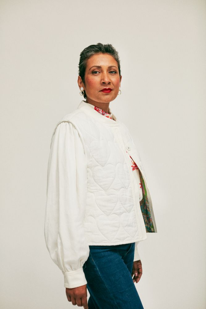 Woman in cream colored jacket looking serious