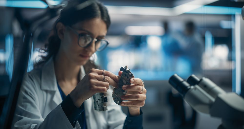 Focused Professional Female Engineer Working on Electronic Circuit Boards.