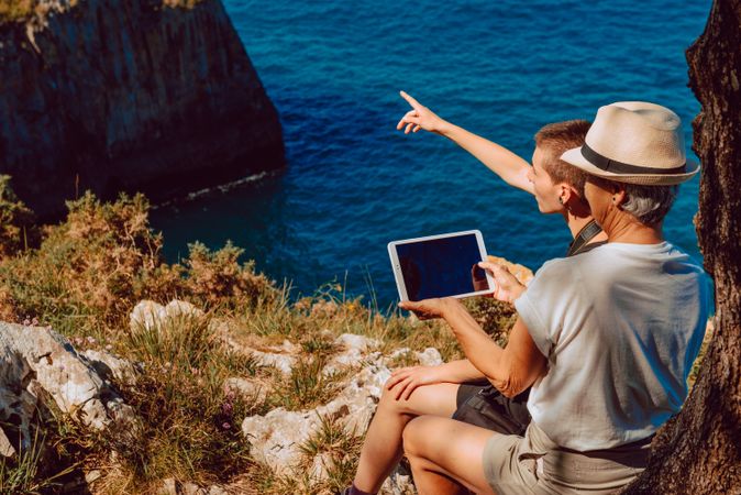 Stylish woman with tablet in hands on coast with older female relative