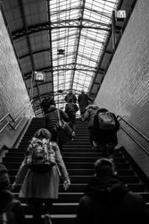 Back of people walking up stairs in station