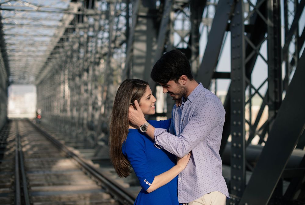 Amorous couple bonding on railway under bridge