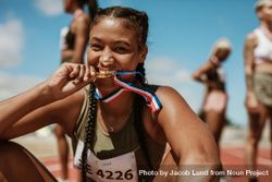 Sports woman enjoying winning a medal in sprinting event at stadium 4AlM85