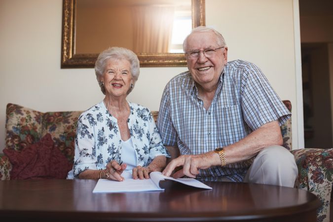 Portrait of a smiling older couple looking over documents