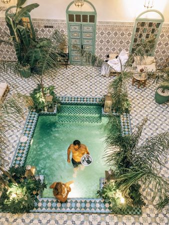 Top view of man and woman in swimming pool in a traditional Moroccan house