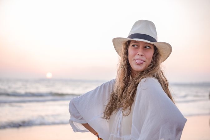 Charming woman in light white dress on wavy beach