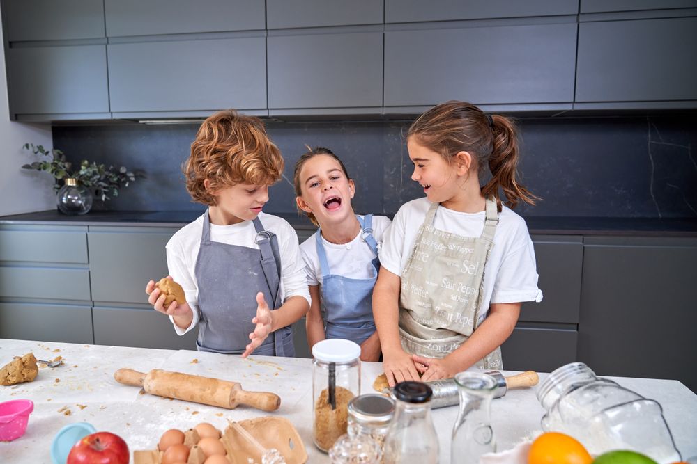 Happy children making cookie dough