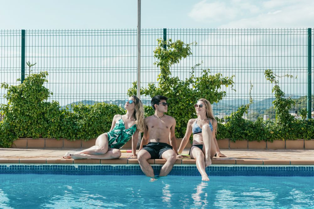 Friends playing with water pistols in the pool