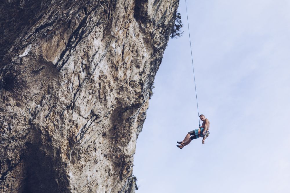 Anonymous climber handing on cliff