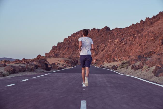 Unrecognizable man running on road
