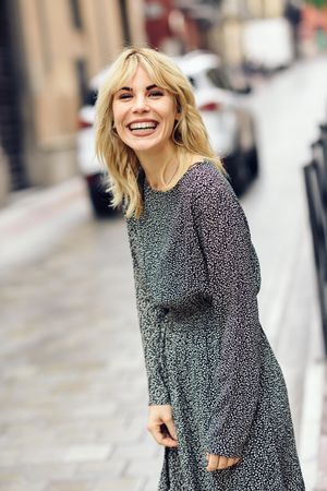 Carefree blonde woman standing in Spanish street