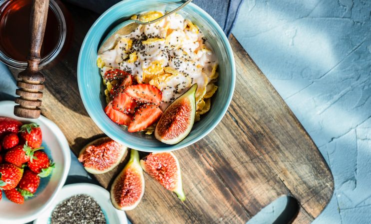 Traditionally healthy breakfast with chia, honey, figs and strawberry on board with copy space