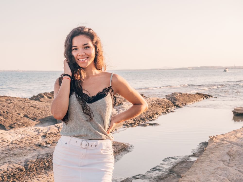 Pretty trendy young woman on beach at sunset