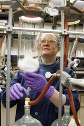 Fort Detrick, MD - USA, Feb 2011: Female scientist draining percolator of plant material 4mZ1zb