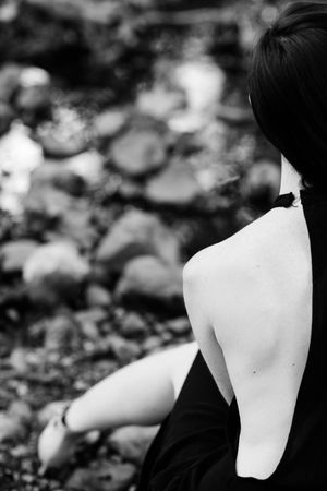 Close up cropped image of woman’s back and shoulders outside in nature