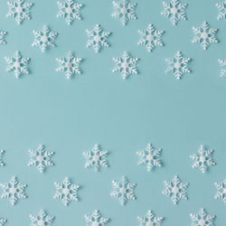 Winter pattern made of uniform snowflakes on blue background