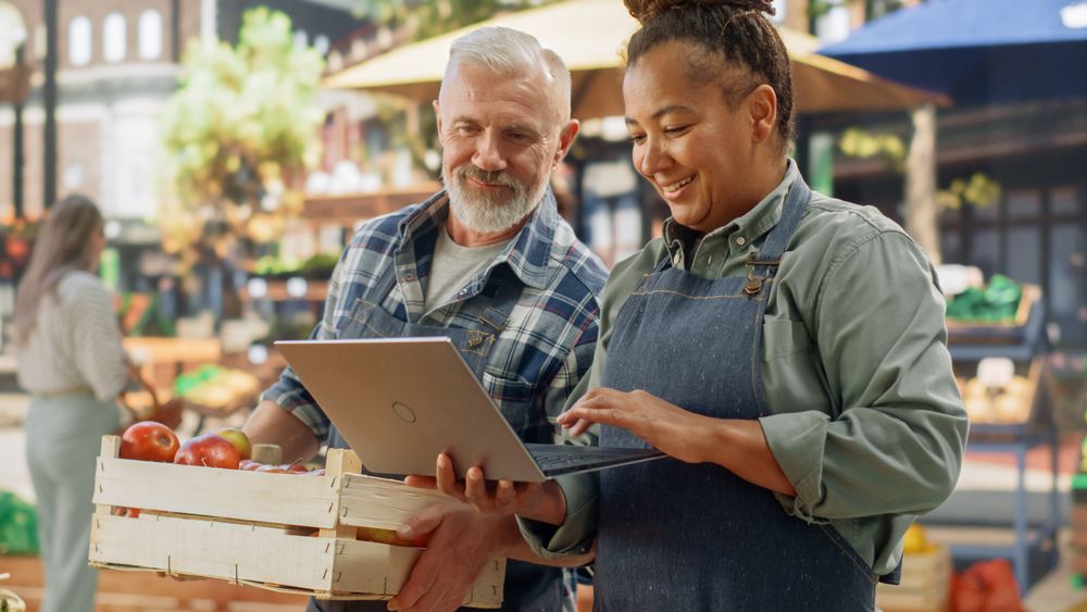 Female and Male Business Partners Managing a Successful Organic Farmers Market Marketplace.