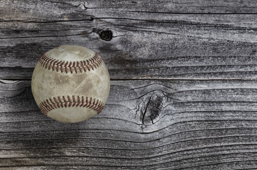 Single used baseball on vintage wooden background