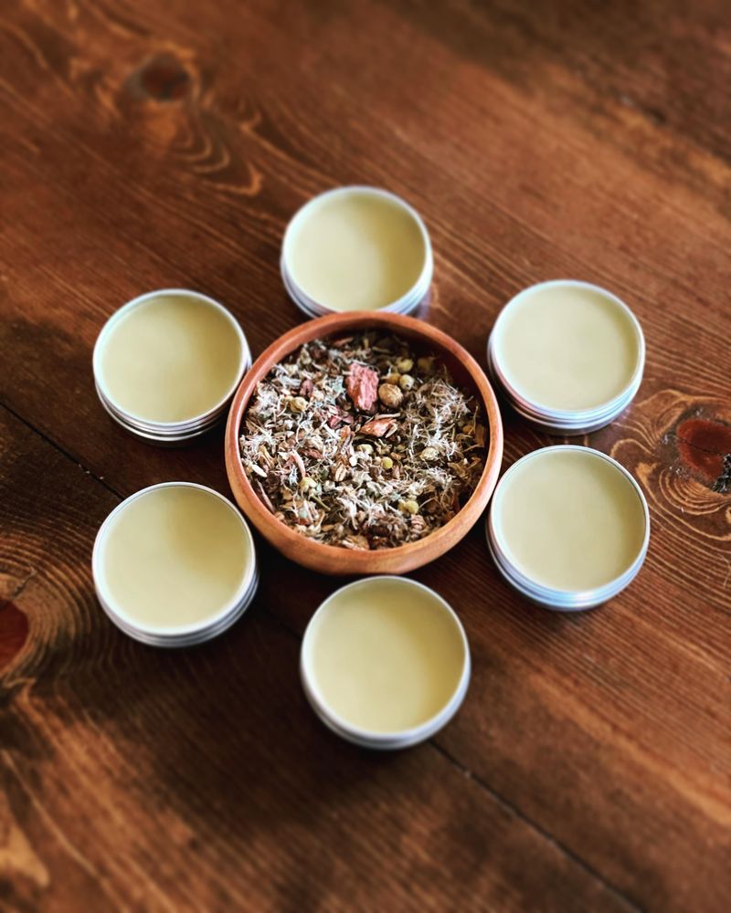 Bowl of herbs surrounded by cannabis salves