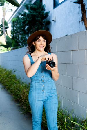 Female photographer smiling while taking a picture outside