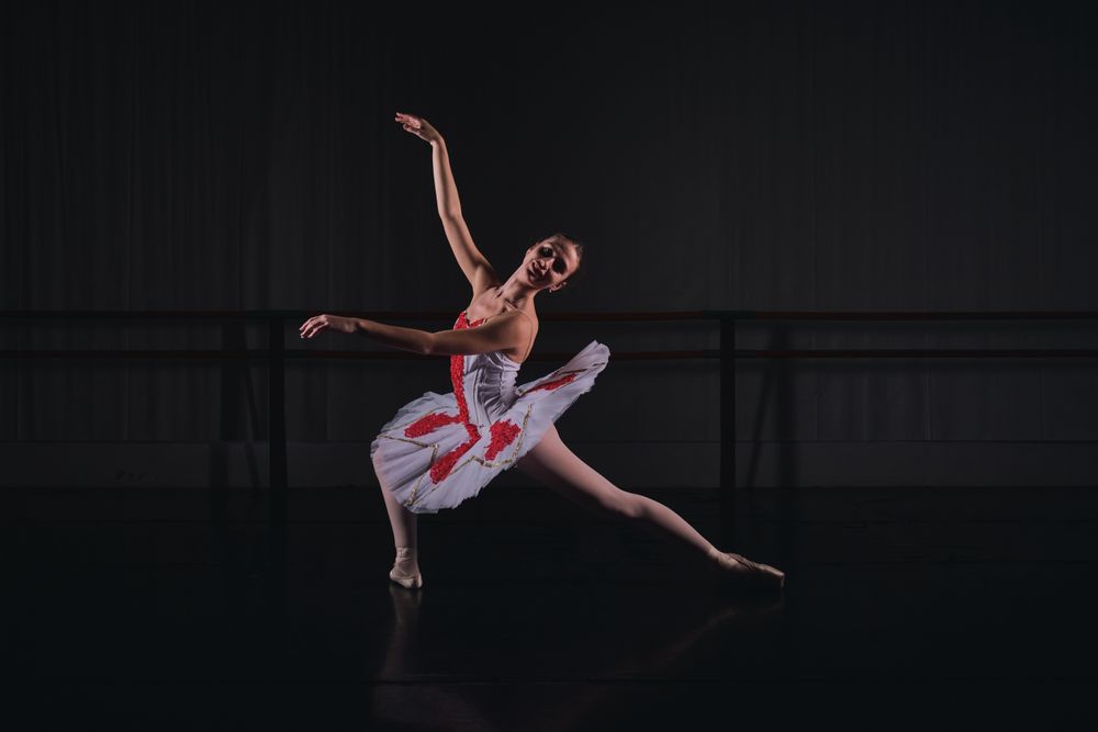 Graceful ballerina dancing ballet role in dark room