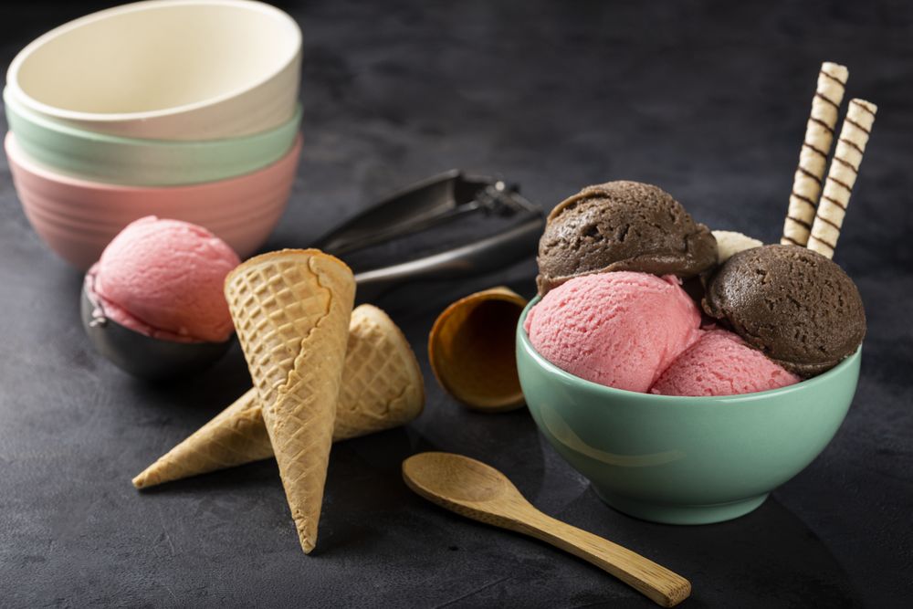 Bowl with Neapolitan ice cream on dark background.