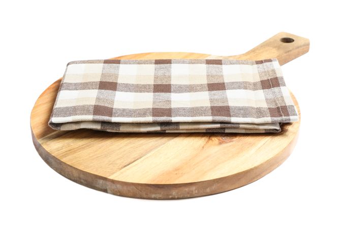 Cutting board with kitchen towel isolated on plain background