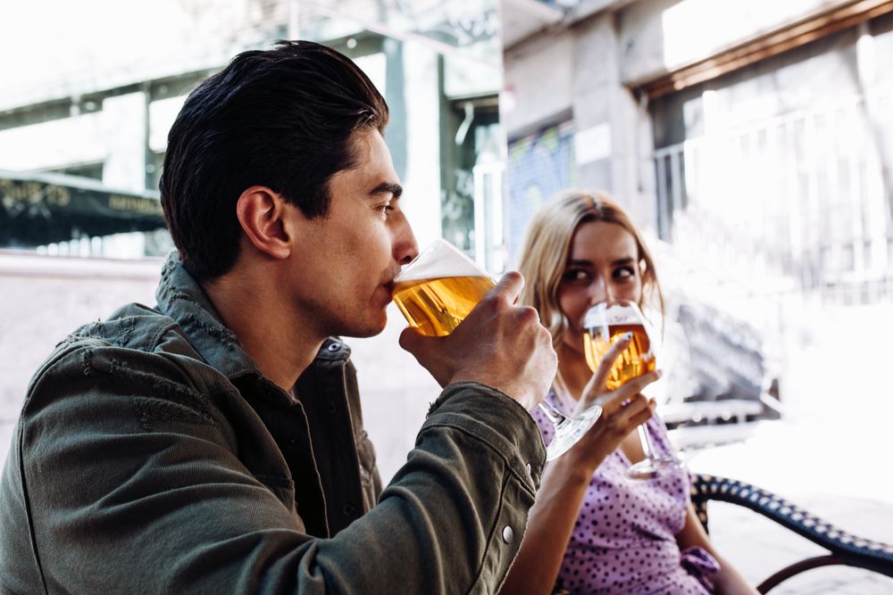 Happy young couple drinking beverages outdoors
