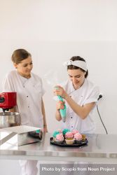 Two female chefs making cupcakes 43VNR5