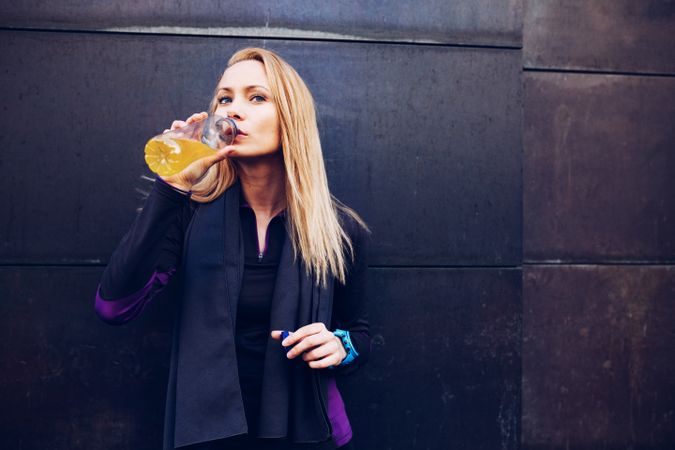 Woman drinking isotonic drink while resting