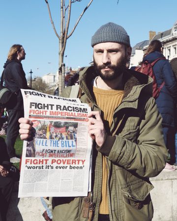 London, England, United Kingdom - March 19 2022: Man holding newspaper saying “Fight Racism"