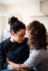 Woman kissing her partner’s forehead