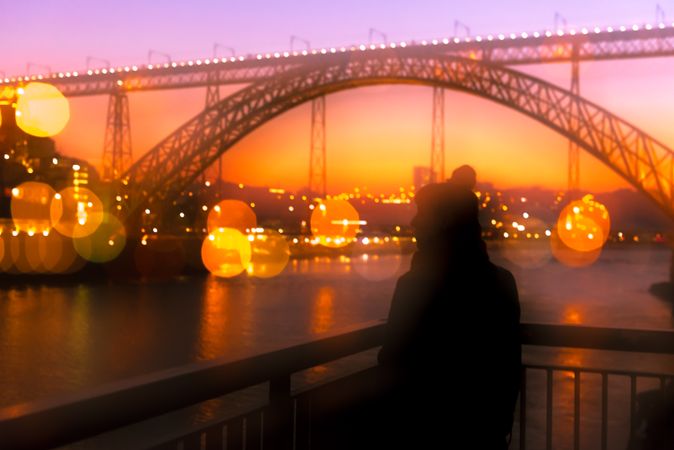Woman looking at river and city in evening