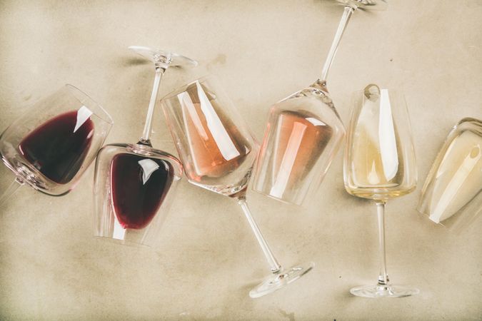 Glasses of wine laying on grey background