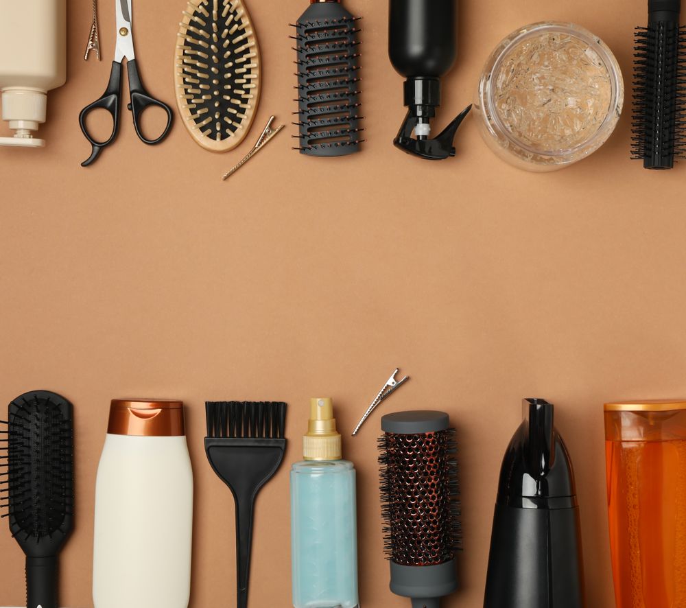 Composition with hairdresser accessories on brown background, space for text