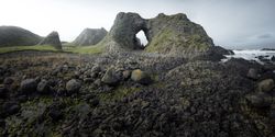 Woman standing inside rocky cave