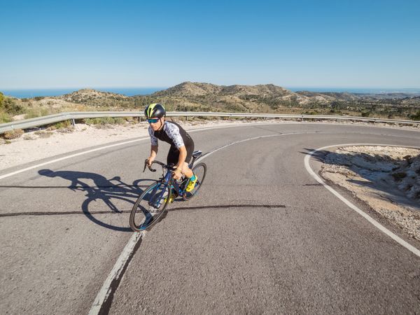 healthy man riding a bicycle on a mountain road in a sunny day