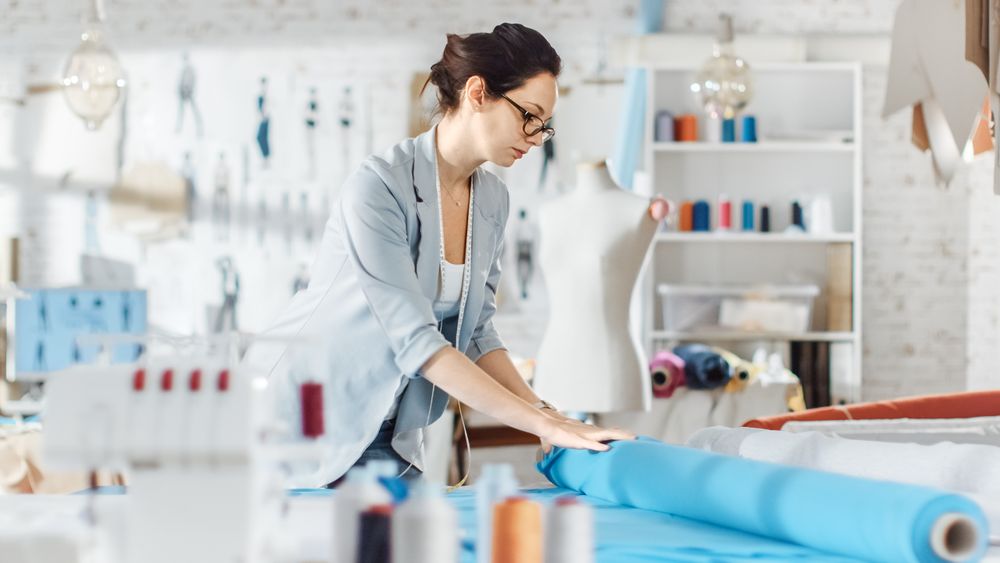 Female fashion, designer, Straightens Roll of Teal Fabrics