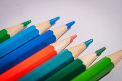 A row of pencils with different colors, including blue, green, and red