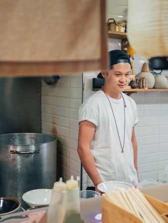Asian male cook standing in kitchen