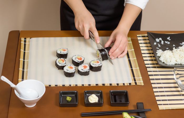 Chef cutting freshly made sushi rolls
