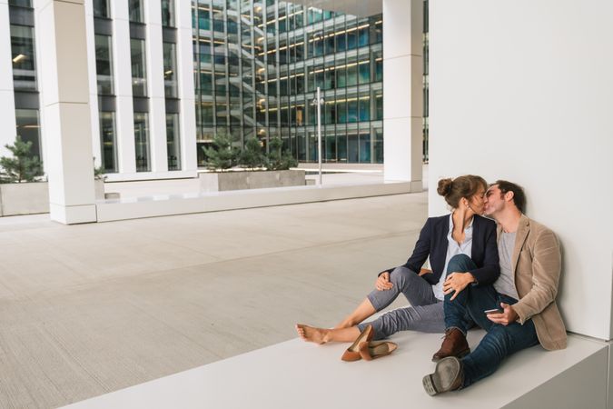 Businesspeople hugging and using smartphone on street